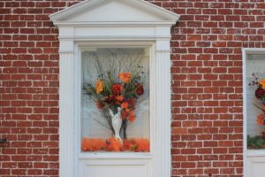 A vase of flowers in the window of a brick building.