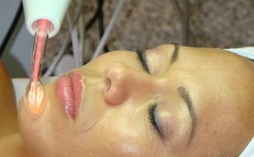 A woman is getting her face waxed