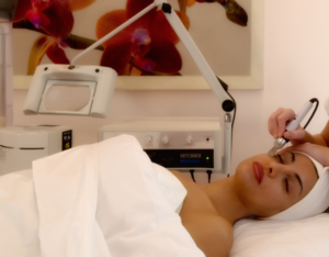 A woman laying in bed with an ear candling device.