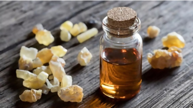 A bottle of honey sitting on top of a wooden table.