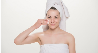 A woman with a towel on her head and shoulders.